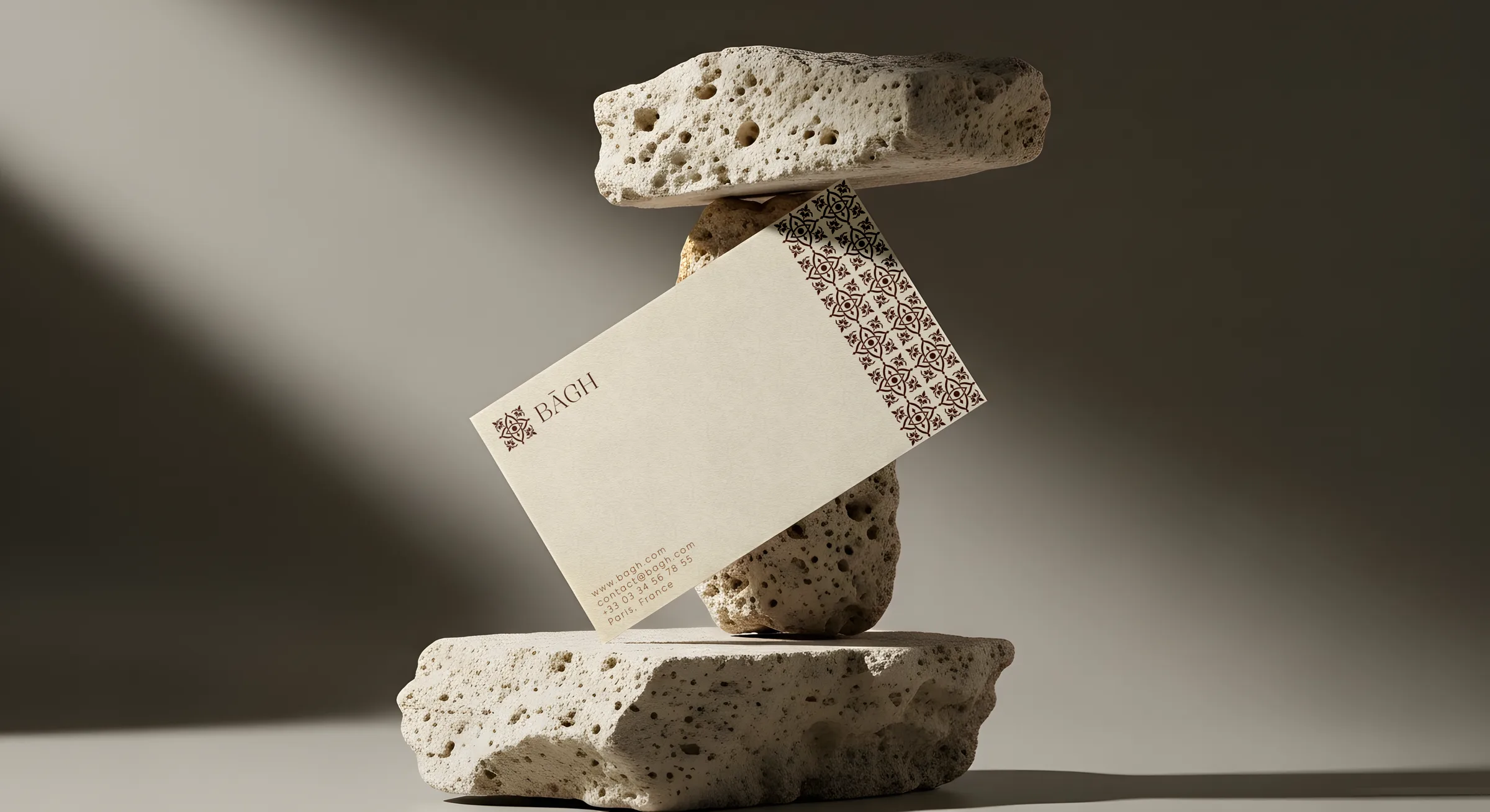 BĀGH business card balanced between stones in raking light